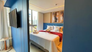 Een moderne hotelkamer met een bed, een aan de muur bevestigde televisie en kunstwerken aan de muur.