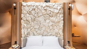 Een moderne slaapkamer met een stenen muur, dakraam, bed en houten details.
