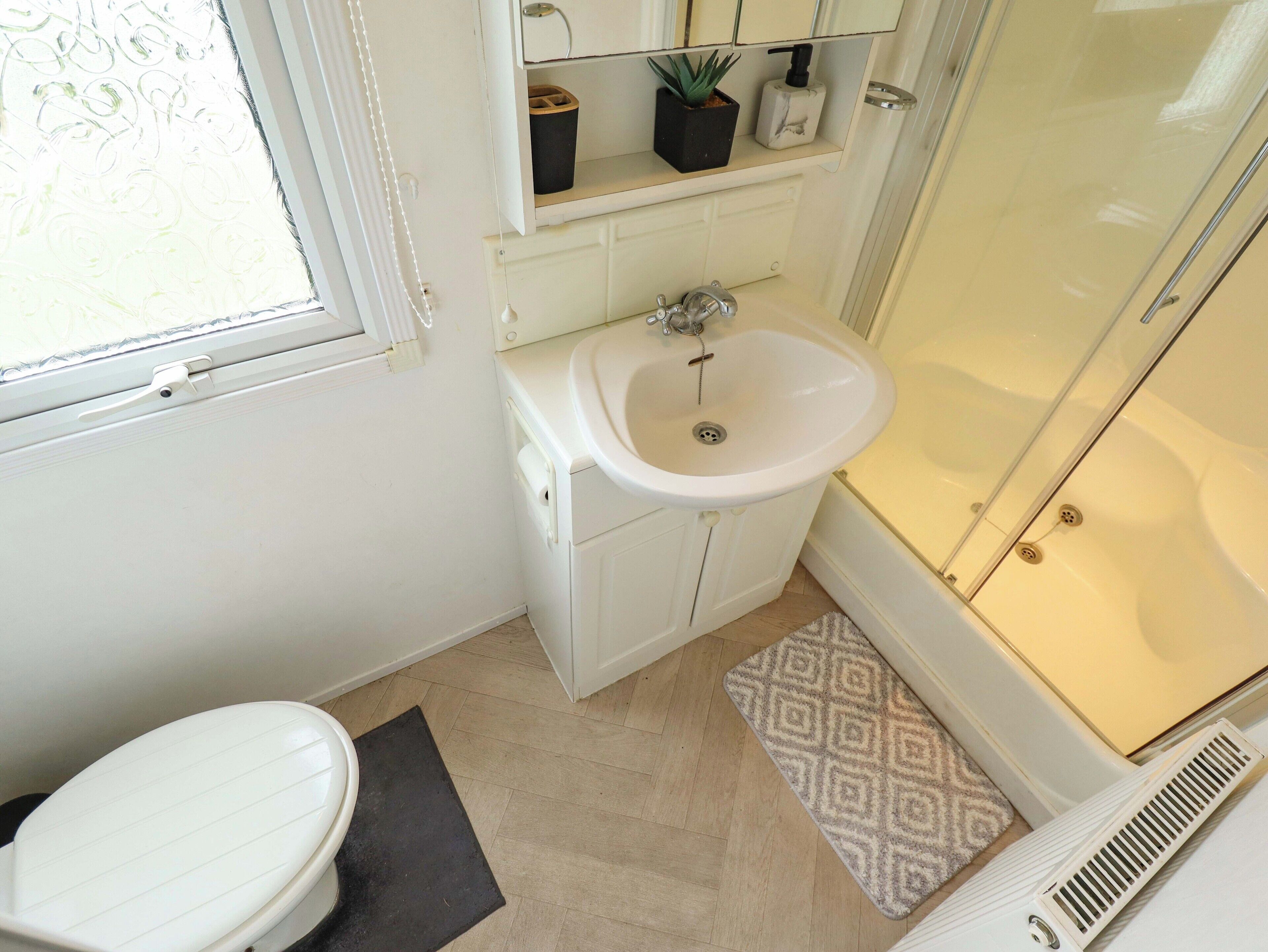 Ein Badezimmer mit Toilette, Waschbecken und Dusche.