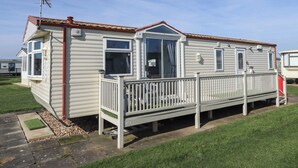 A mobile home with a front porch, a small deck, and a satellite dish. - Towervans Z11 (Mablethorpe)