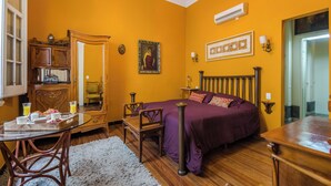 A room with a bed, a wooden dresser, a chair, a table with breakfast items, and a mirror. - Sky Garden [Art Nouveau] Wild Terrace & Mini Pool (Montevideo)