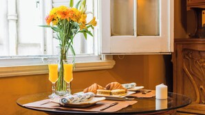 A breakfast table with croissants, a candle, and a vase of flowers. - Sky Garden [Art Nouveau] Wild Terrace & Mini Pool (Montevideo)