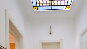 A hallway with a patterned floor, a wooden chair, a cabinet, and a stained glass ceiling. - Sky Garden [Art Nouveau] Wild Terrace & Mini Pool (Montevideo)