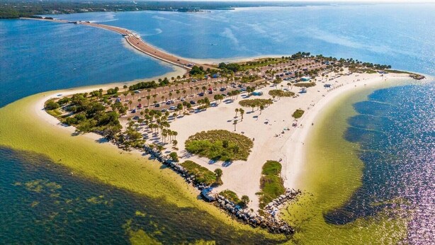 An aerial view of a coastal resort with a beach, clear waters, and a road leading to the shore. - Beautifully restored early-1900s Church. In Historic District + Pet Friendly (Tarpon Springs)