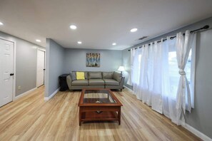 Una sala de estar con un sofá, una mesa de centro y un cuadro en la pared.