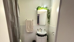 Un baño pequeño con inodoro, lavabo y cortina de ducha.