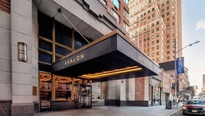 Een hotelingang met een modern design, met een opvallende luifel en grote ramen.
