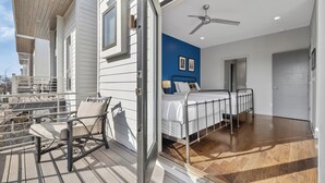 Un dormitorio con cama, ventilador de techo y vistas al exterior.