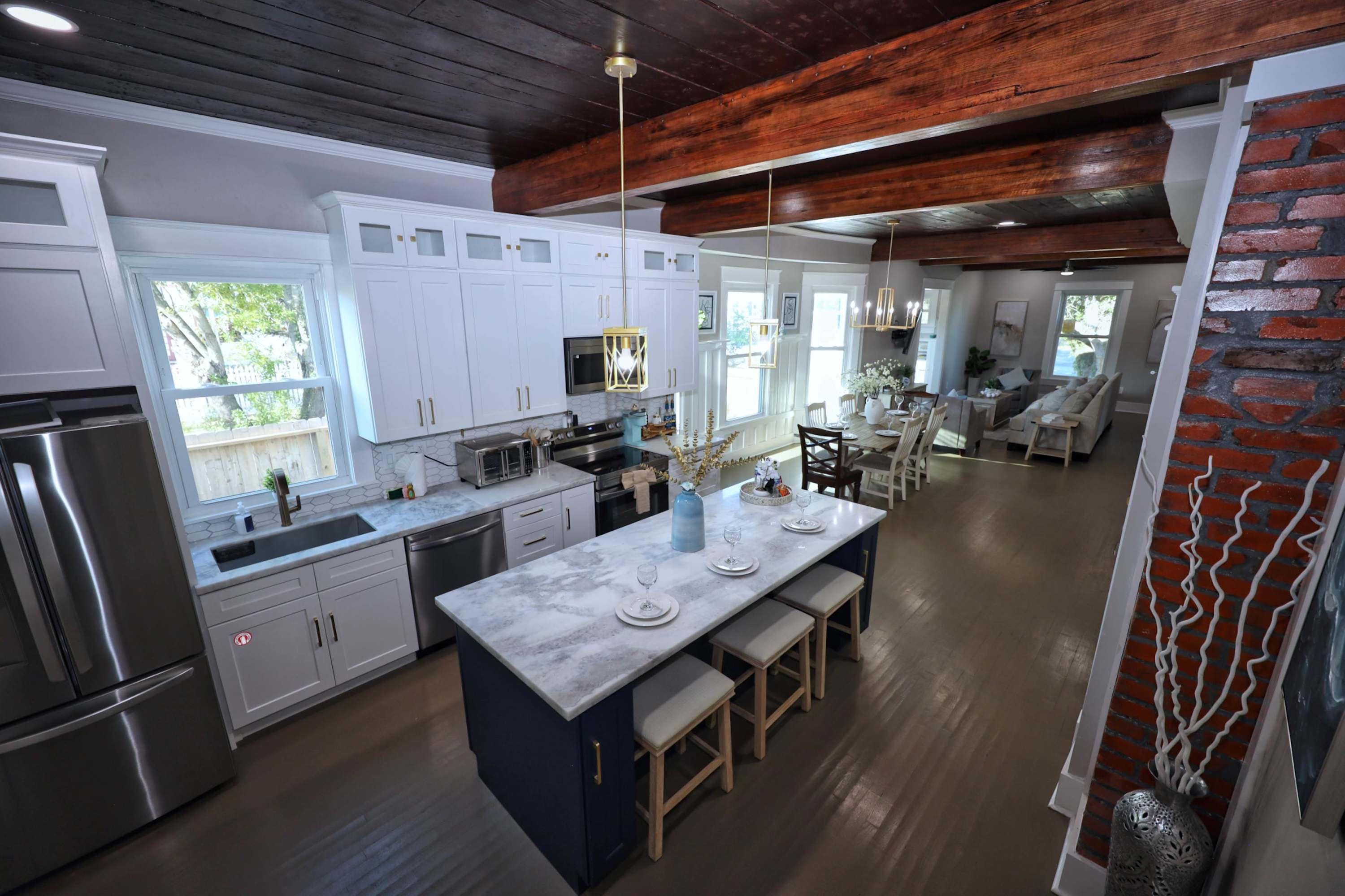 A modern kitchen with white cabinets, stainless steel appliances, and a central island with seating.