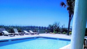 A swimming pool with lounge chairs, a lifeguard duty sign, and a palm tree. - Our 3 bedroom unit is expansive, and perfect for large parties going on vacation (North Myrtle Beach)
