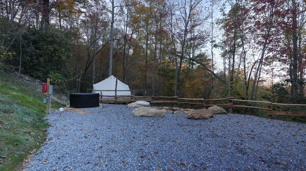 A tented area with a gravel path, wooden fence, and rocks.