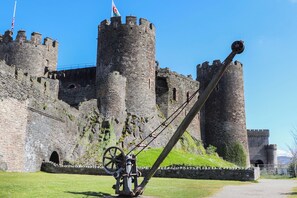 A historic castle with a prominent drawbridge and a flag on top of one of the towers.