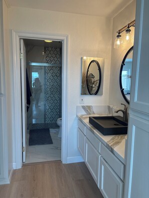 A modern bathroom with a vanity, a mirror, and a shower area. - Penthouse Condo, newly remodeled.  Amazing Views. Pool, hot tub, Parking spot. (San Diego)