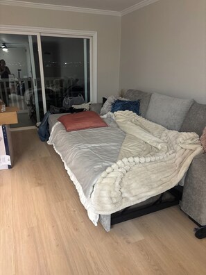A bedroom with a bed, a sofa, a sliding glass door, and a wooden floor. - Penthouse Condo, newly remodeled.  Amazing Views. Pool, hot tub, Parking spot. (San Diego)