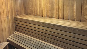 Eine Sauna mit Holzbänken und leicht abfallendem Boden.
