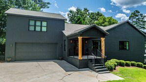 Une maison à deux étages avec un garage, une véranda et un escalier menant à l’étage supérieur.
