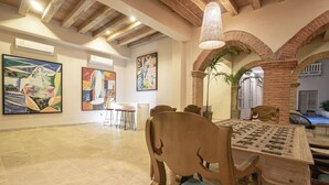 Un'area pranzo con un tavolo e sedie in legno, un lampadario e opere d'arte alle pareti.