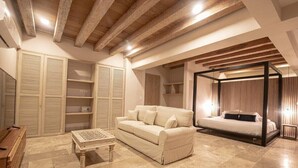 Una camera da letto con un letto, un divano, un tavolino e scaffali a muro.