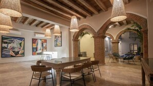 Un interno con zona pranzo, opere d'arte alle pareti e un arco in mattoni.