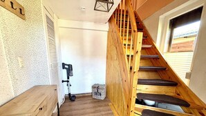 Eine Holzt Treppe mit einer Bank, einem Wandheizkörper und einem Fenster.