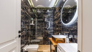 A bathroom with a toilet, a sink, a mirror, and a shower. - Vista Mare Horizon | Patio with Amazing Seaview by PikHost (Vlorë)