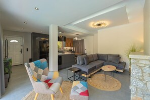 A modern living room with a sectional sofa, a coffee table, and a fireplace. - Villa Omega - Two Bedroom Villa, Sleeps 4 (Ditiki Mani)