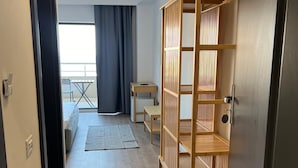 Un pasillo que conduce a una habitación con un armario de madera, una mesita y una silla.