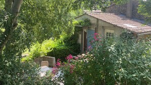 A rustic house with a tiled roof, surrounded by lush greenery and flowering plants. - La Félicité: the river, nature, time to yourself. (duniere sur eyrieux)