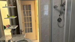 A bathroom with a shower, sink, and toilet.