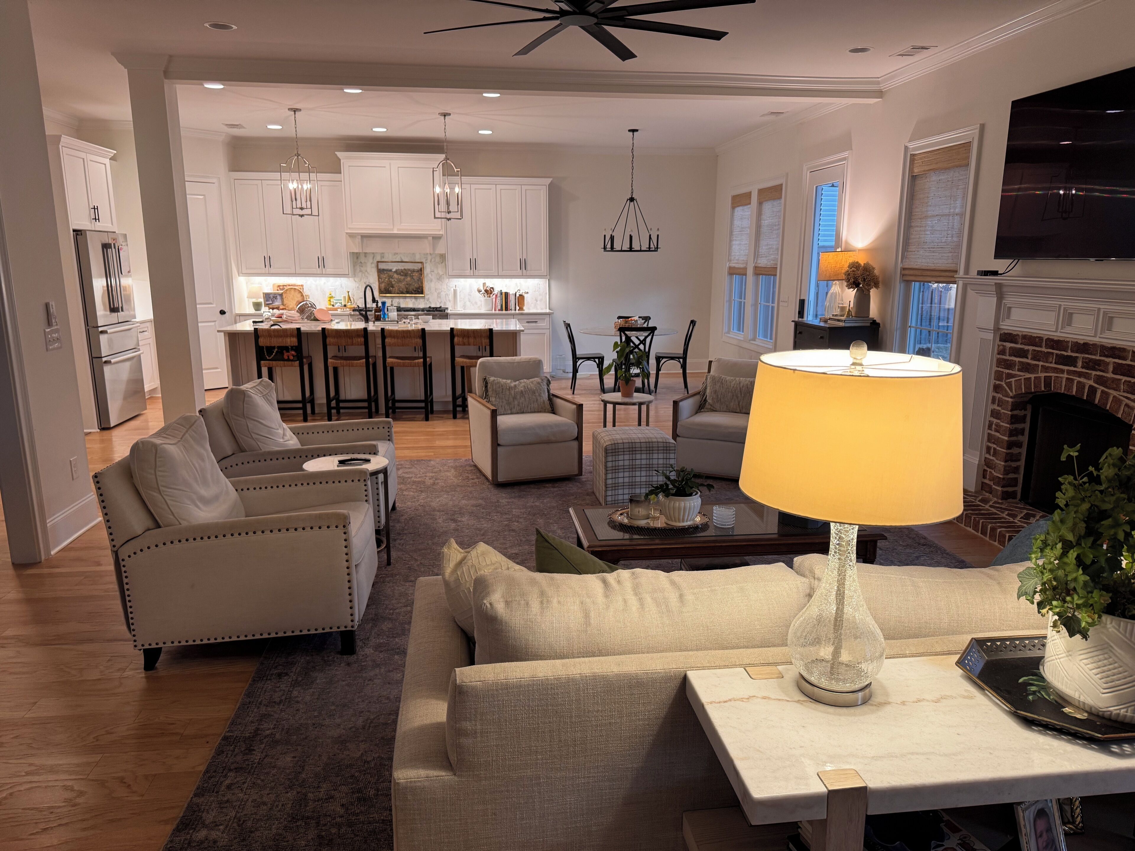A spacious living area with a sofa, armchairs, a coffee table, and a TV.