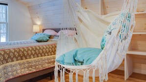 A room with a bed, a hammock chair, and a wooden ceiling. - Tiny Acres: A Storybook Tiny Home, 4 Mi. to CDP (Milford)