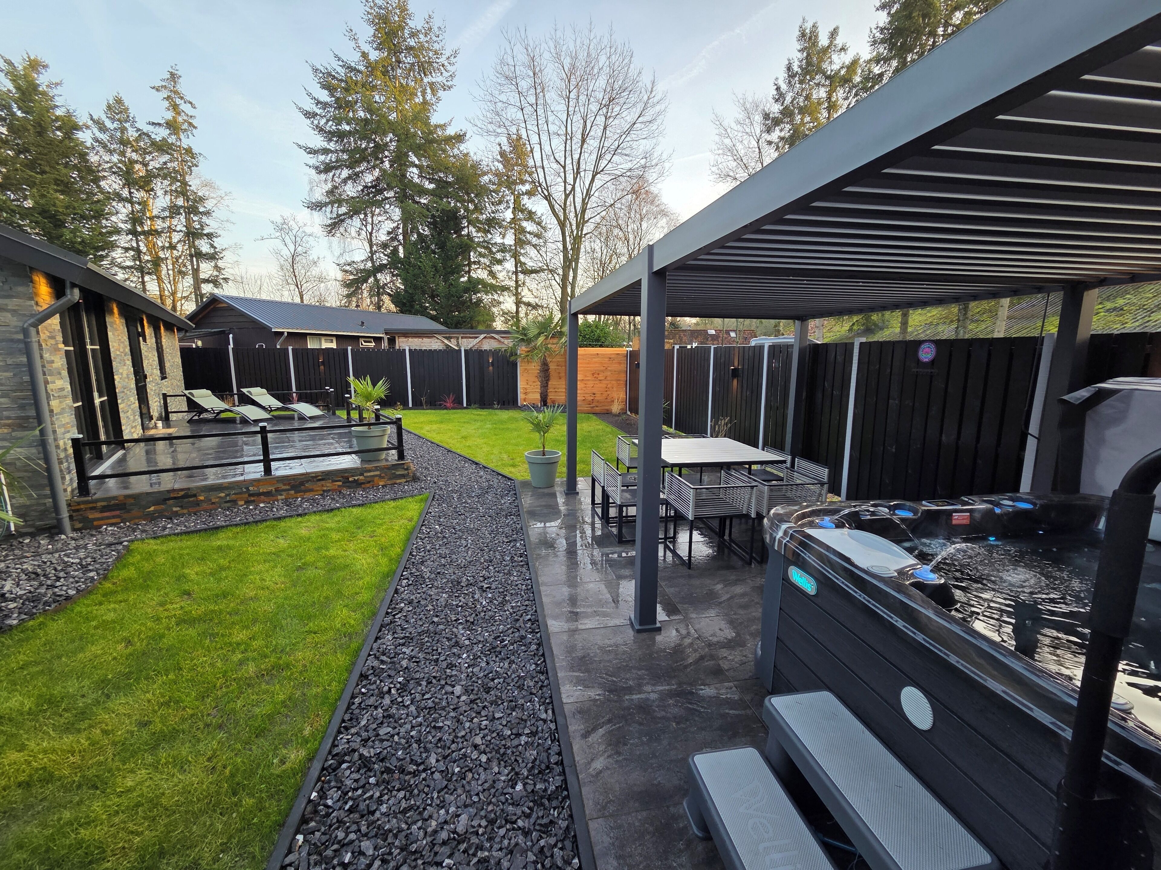 A patio area with a hot tub, seating, and a covered section.