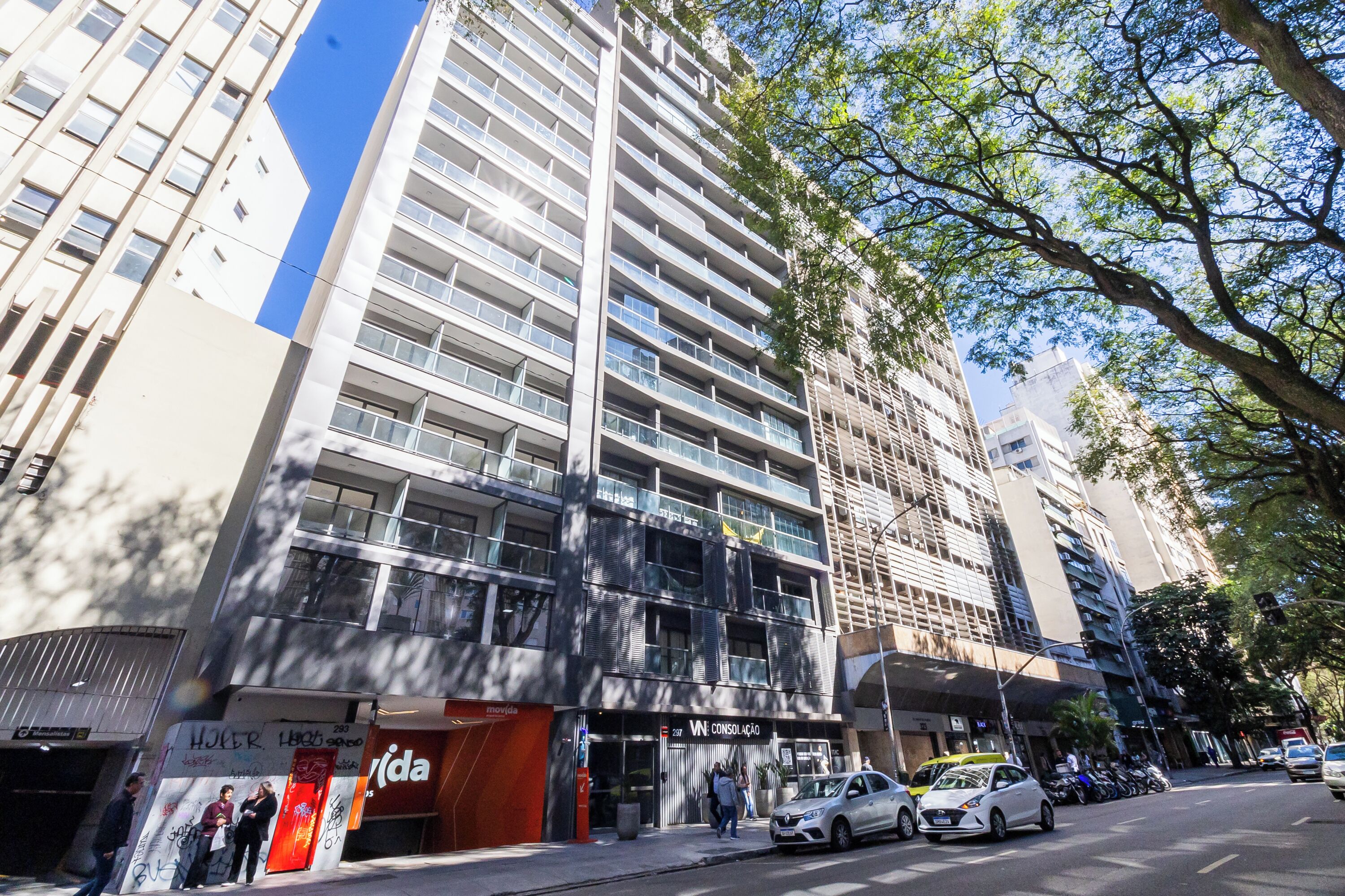 A multi-story building with a modern architectural design, featuring balconies and large windows.