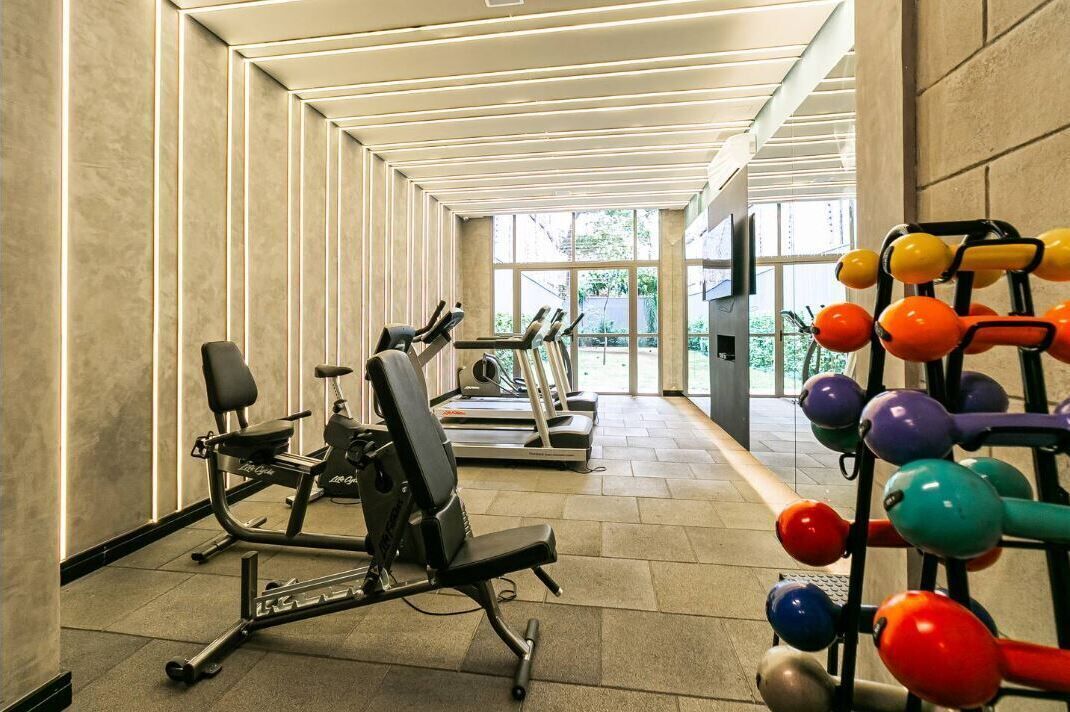 A gym with exercise equipment, a treadmill, and a weight rack.