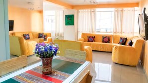 A living room with a sofa set, a coffee table with a vase, and a television. - Apartment close to the main square + airport pickup (cusco)