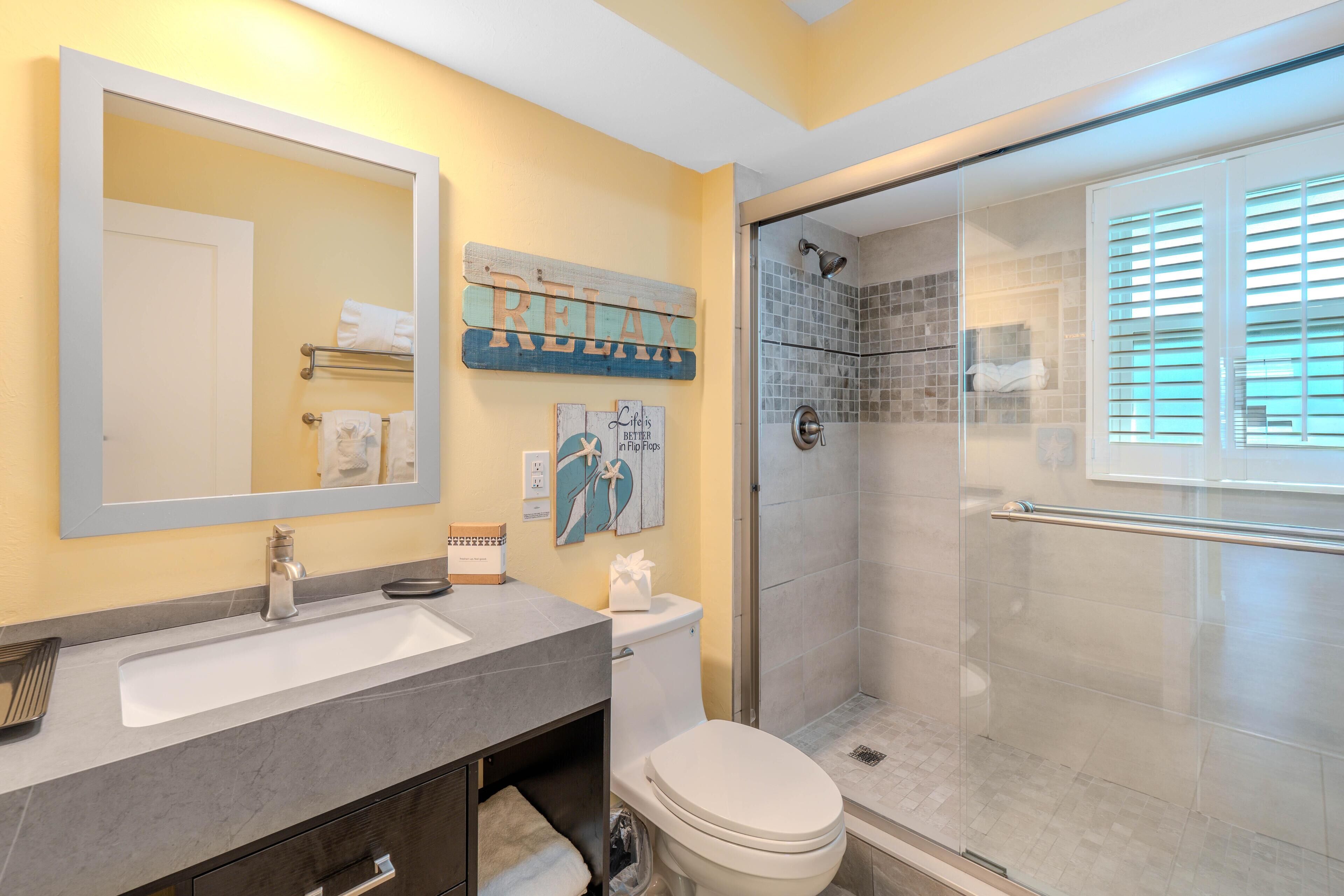 A bathroom with a sink, toilet, and shower.