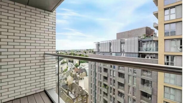 Un balcone con vista sugli edifici circostanti e un cielo sereno.
