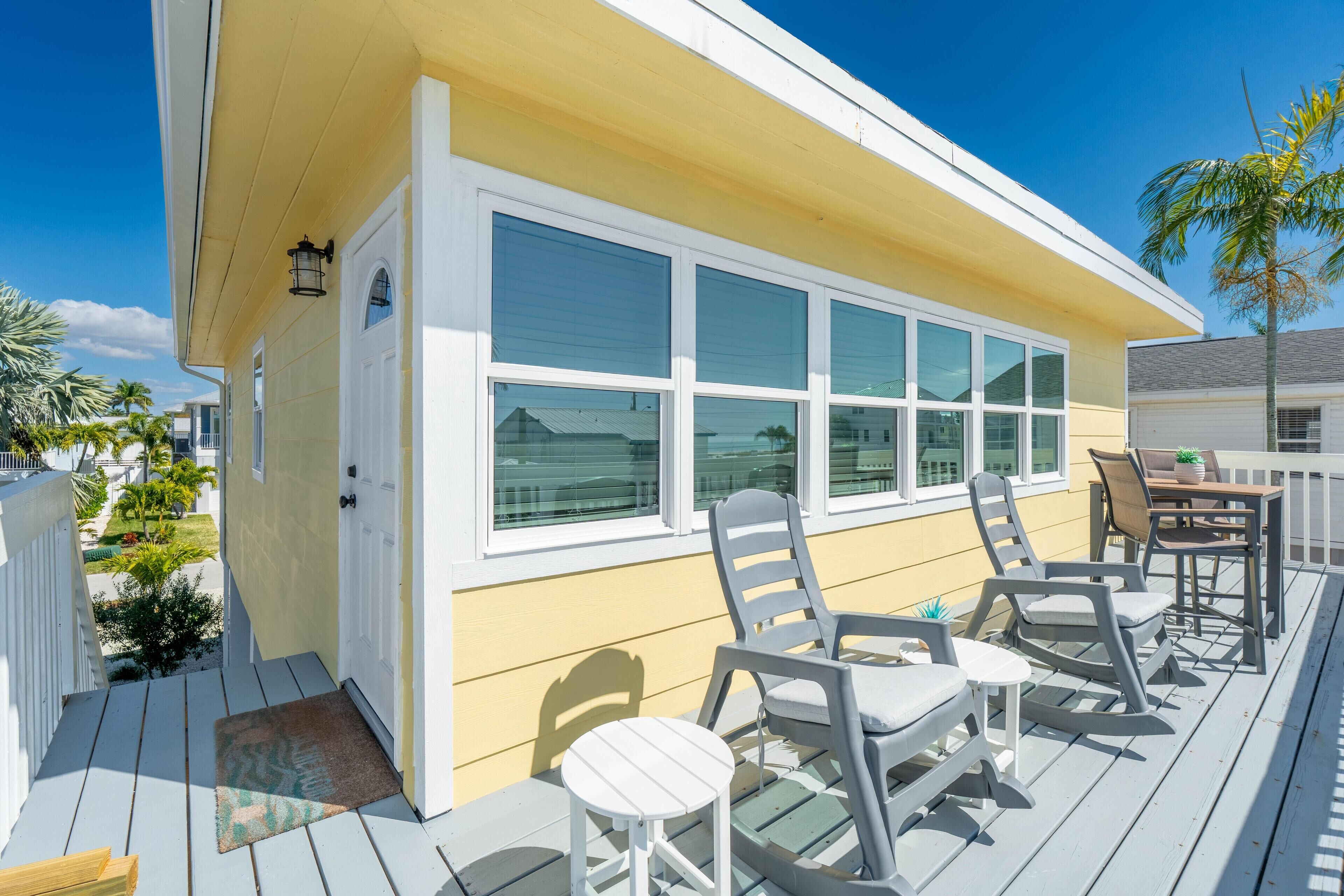 A deck with outdoor furniture, a door, and windows.