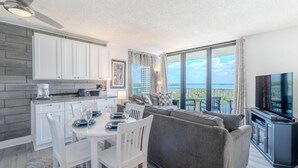 Un salon moderne comprenant un coin repas, un canapé, un téléviseur et un balcon avec vue.
