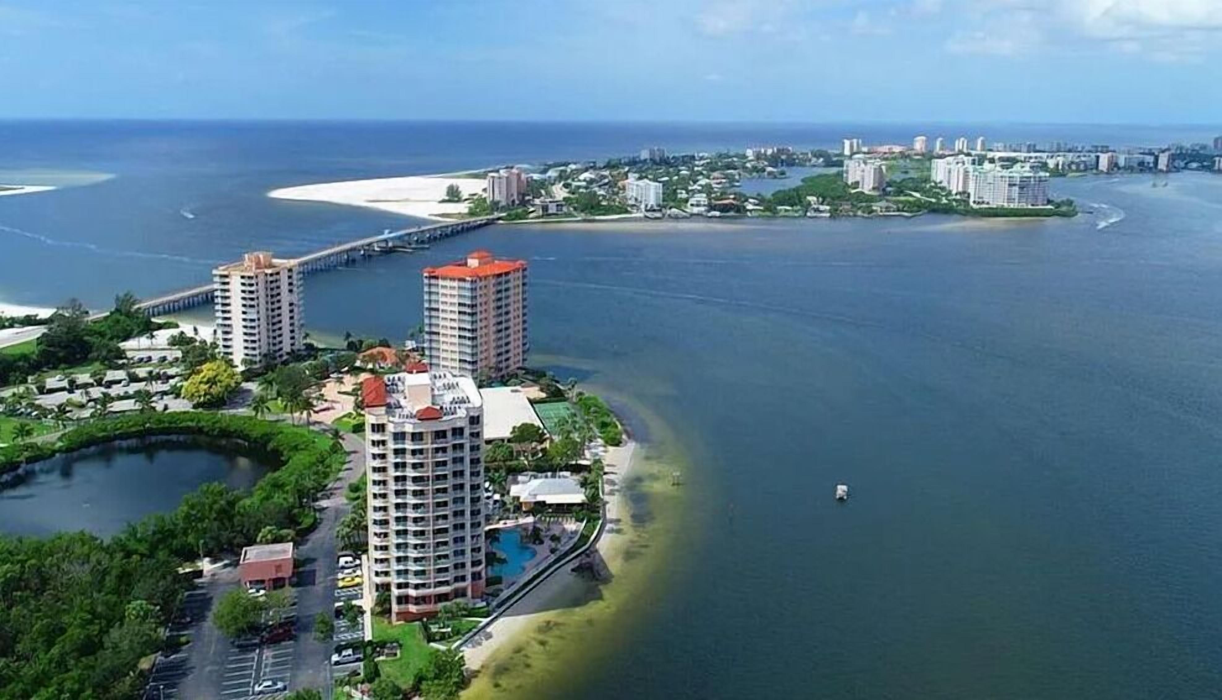 A coastal hotel with multiple high-rise buildings, a marina, and a beach area.