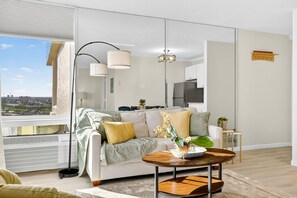 A modern living room with a sofa, coffee table, and a view of the city. - Estero Beach & Tennis Club-penthouse 1A (Fort Myers Beach)