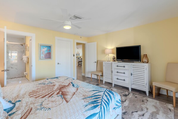 A bedroom with a bed, a TV, a dresser, and a chair. - 218 Mermaid Beach House (Fort Myers Beach)