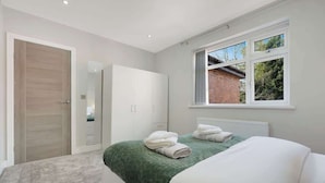 Un dormitorio con cama, armario, ventana y puerta.