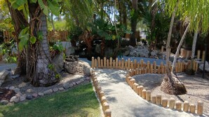 Un sentier de jardin bordé d’une clôture en bois, de rochers et de différentes plantes.