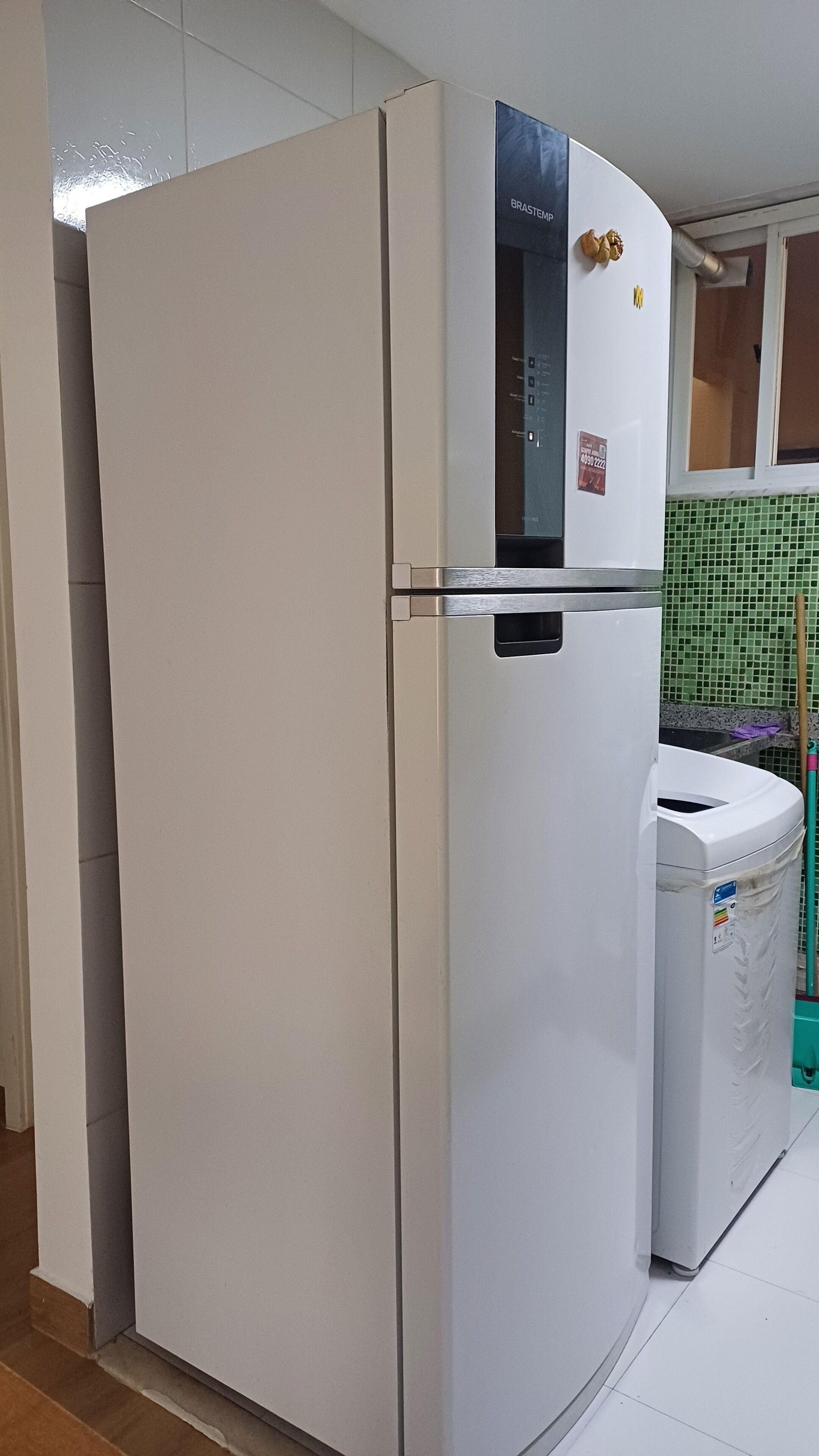 Un réfrigérateur blanc doté d’un panneau de commande et d’un petit autocollant.