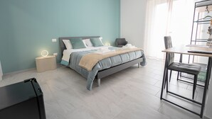 Ein modernes Schlafzimmer mit Bett, Nachttischen, Schreibtisch und Stuhl.