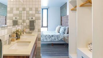 Een moderne badkamer met een wastafel, een douchegedeelte en een inloopkast met planken.