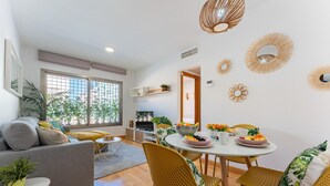 Ein modernes Wohnzimmer mit einer Couch, einem Esstisch, Stühlen und Wandbildern.
