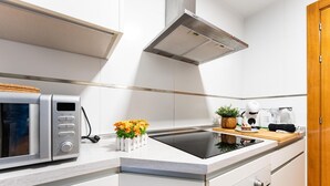 Eine moderne Küche mit Mikrowelle, Herd und Kaffeemaschine.