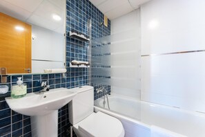 Ein Badezimmer mit weißem Waschbecken, WC und Badewanne.